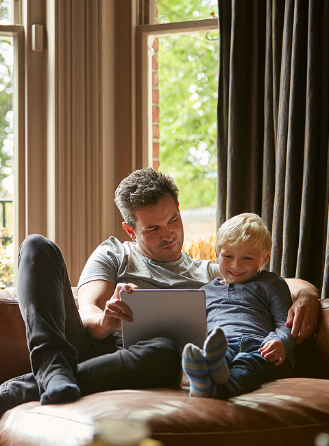 Family using a tablet on a couch